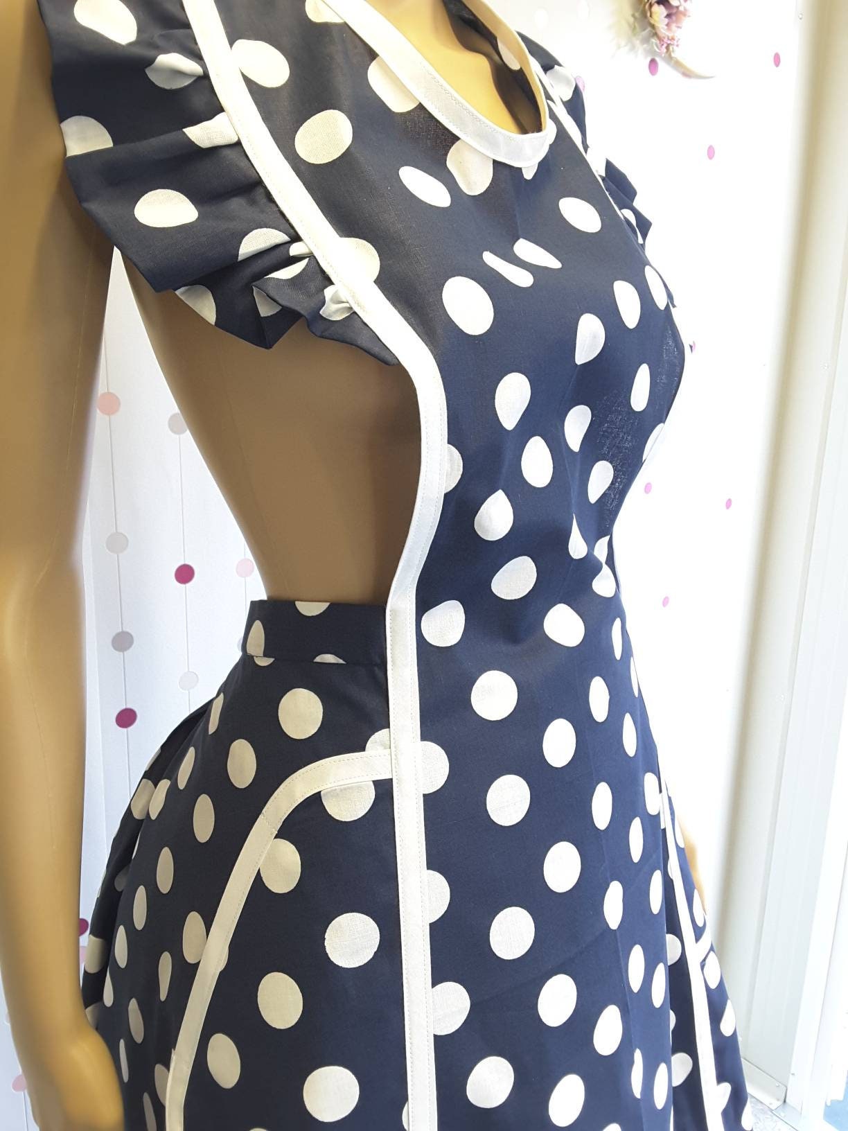 Retro style blue polka dot apron, detail of a pocket with whte bias trim