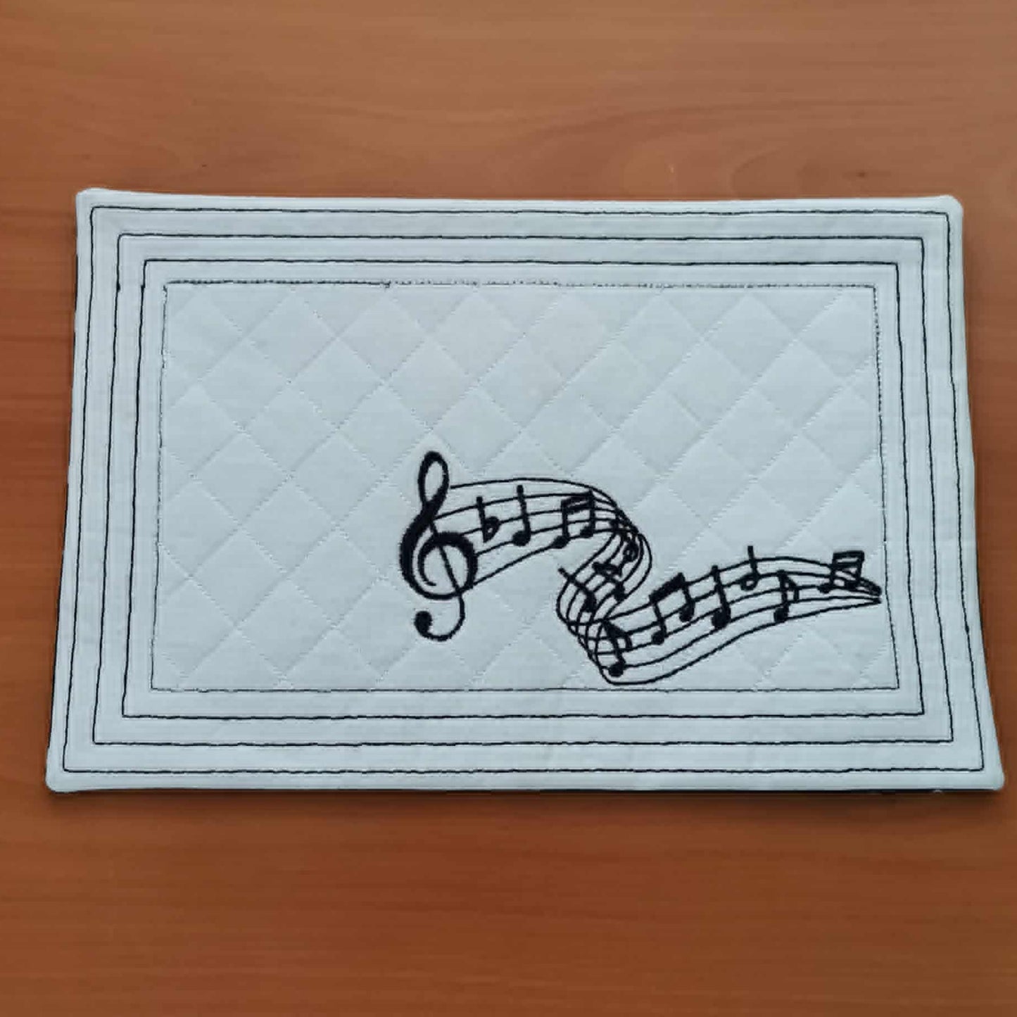Rectangular mat with musical notes design on a wooden surface