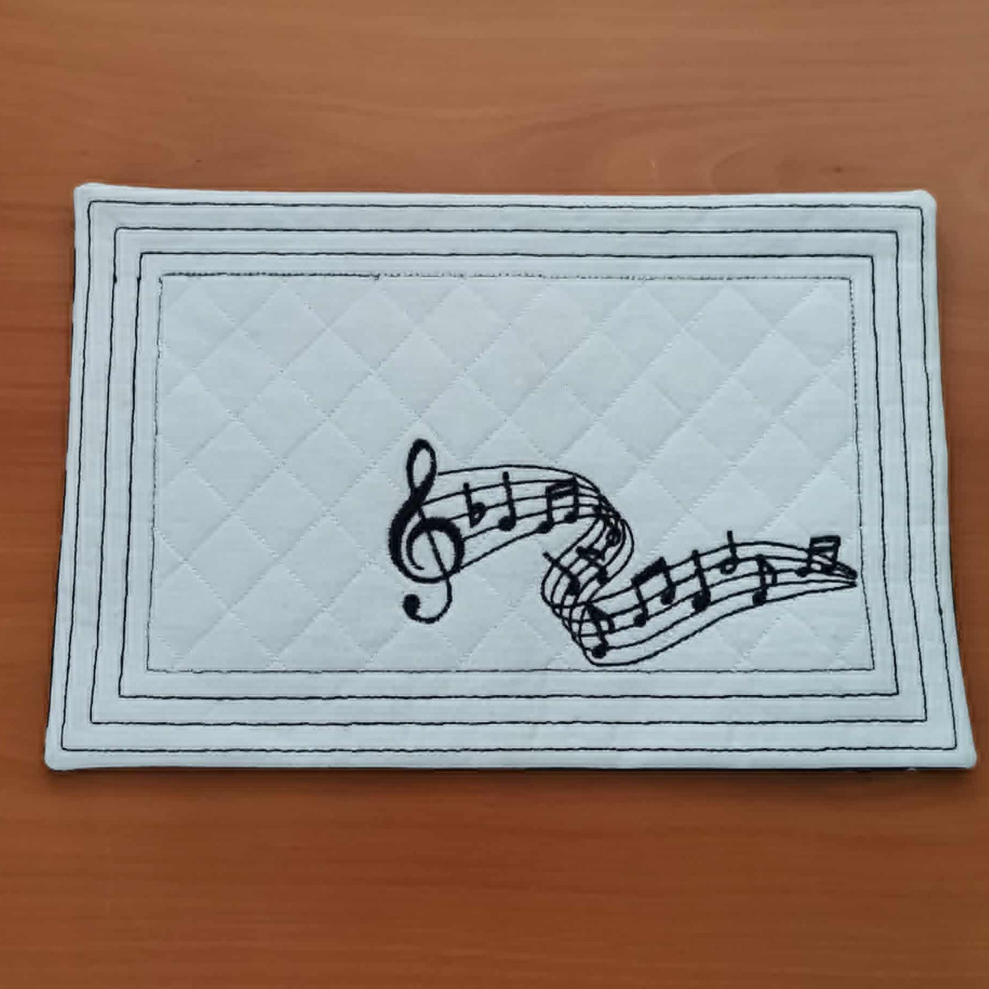 Rectangular mat with musical notes design on a wooden surface