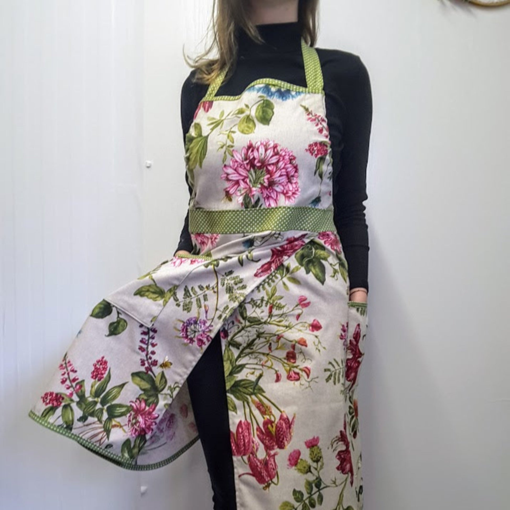 A person wearing a floral split skirt apron with pockets, garden ad utility apron Ella by Katrushka