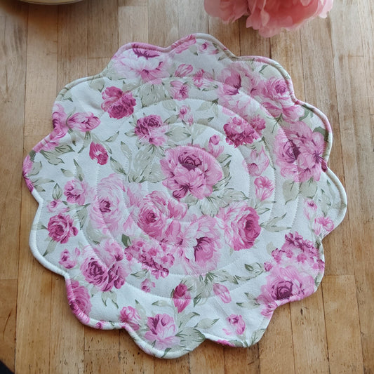 Round quilted placemat with scalloped edges in soft pink roses print