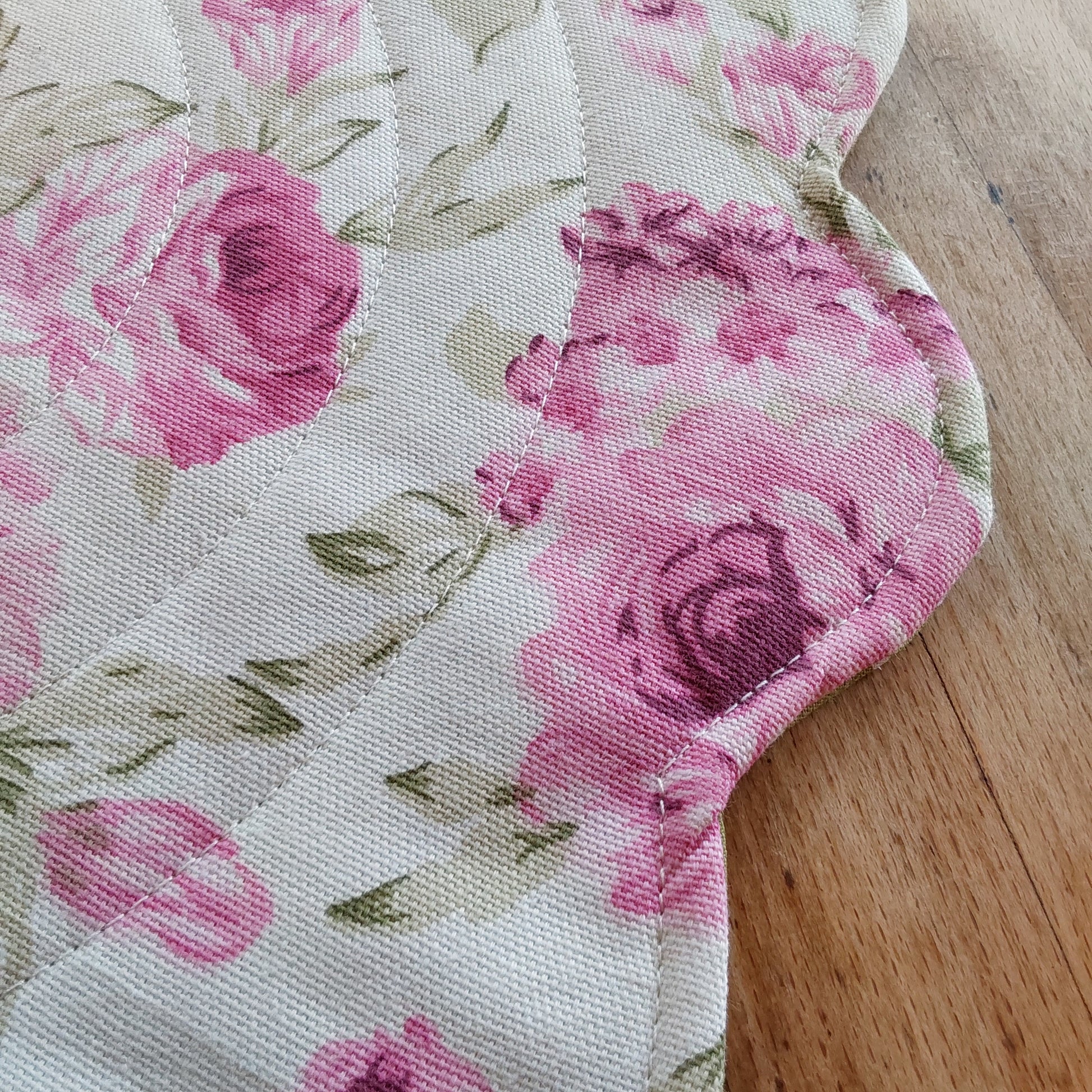 Detail of a round quilted placemat, photo showing scalloped edge