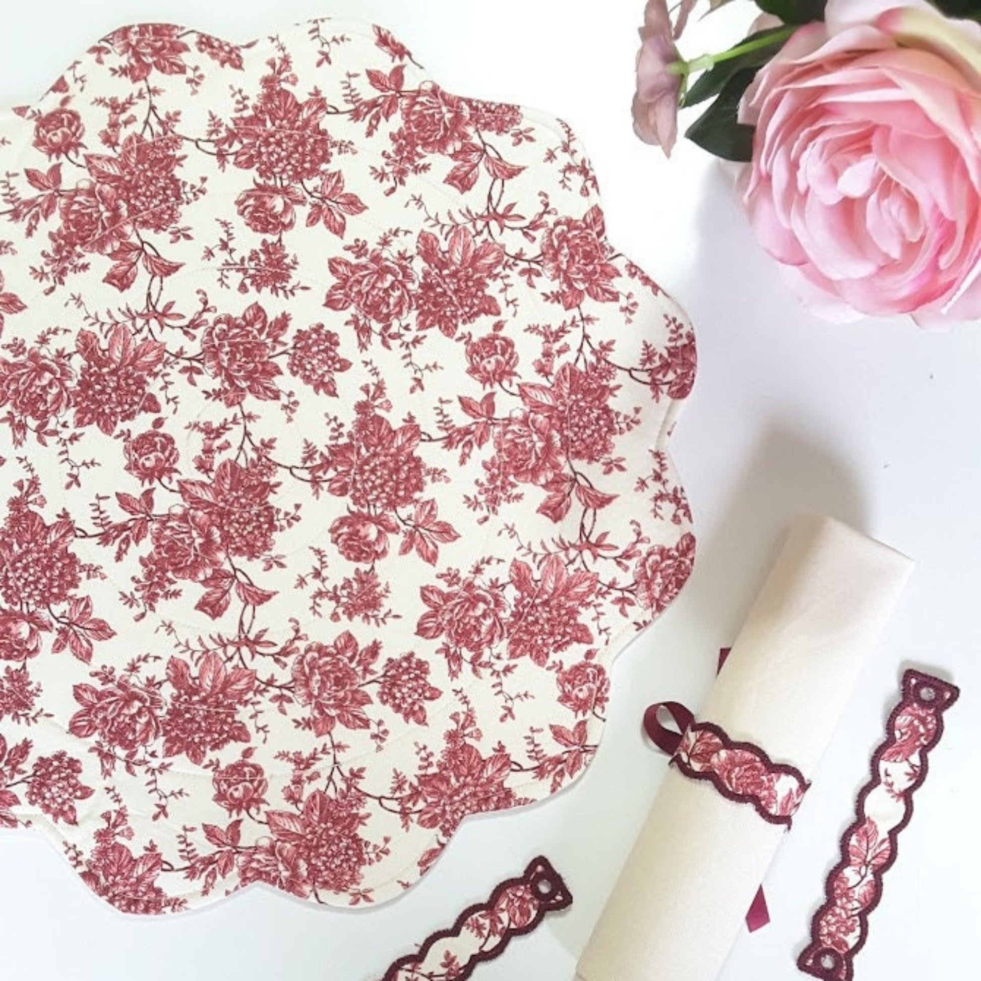 Round quilted placemats in red toile floral print, scalloped edge