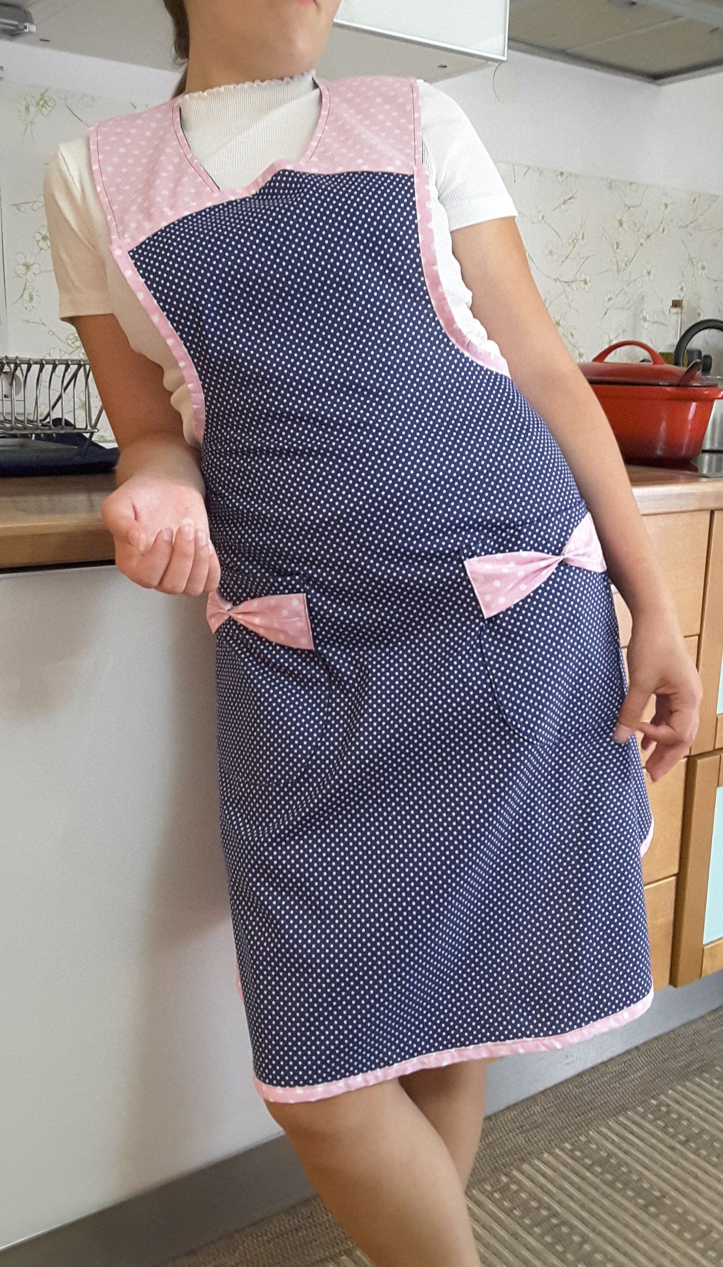 Vintage style blue and pink polka dot apron with pink neckline and pockets with pink bows